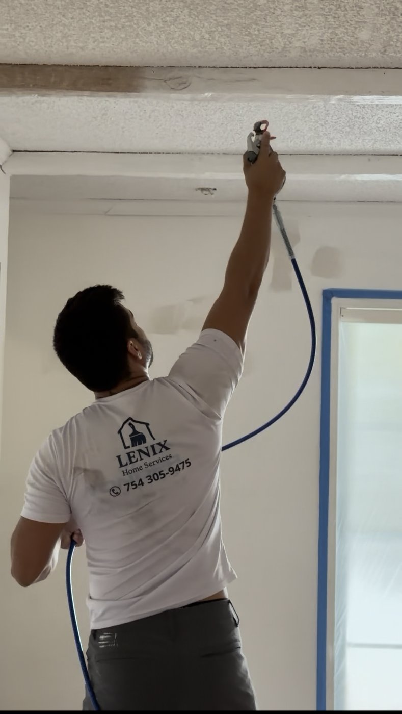 Lenix Home Services technician spray painting ceiling trim